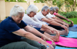 Anziani multietnici sorridenti che fanno esercizi di stretching